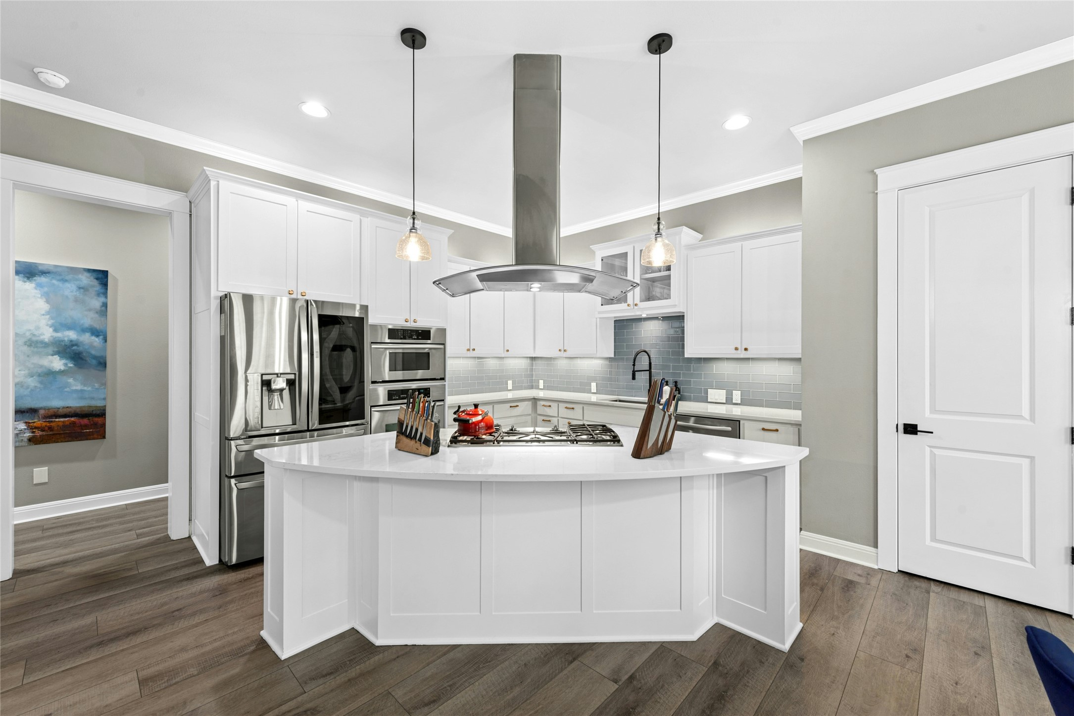 279 Rugged Earth Drive Austin, TX 78737 - Photo 17 of 40 Kitchen featuring island range hood, white cabinets, stainless steel appliances, a large island with sink, and ornamental molding