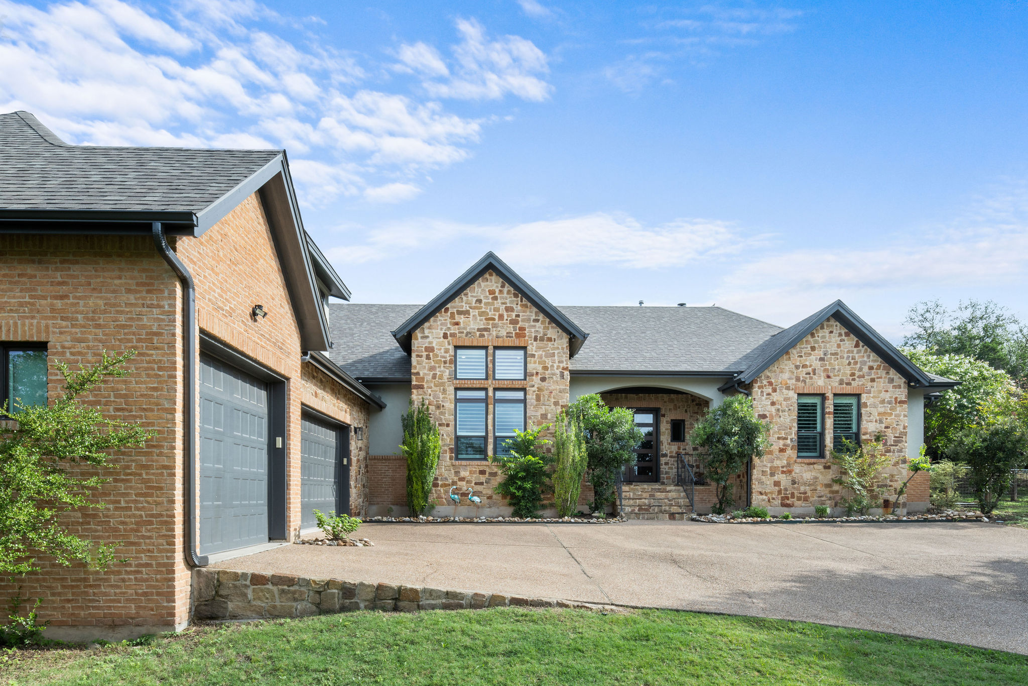 279 Rugged Earth Drive Austin, TX 78737 - Photo 2 of 40 View of front of property with driveway, a shingled roof, a garage, and brick siding