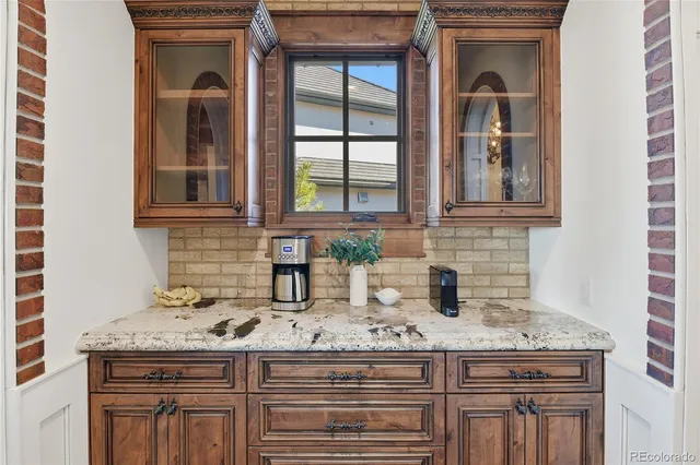 a kitchen with granite countertop a sink stove and cabinets