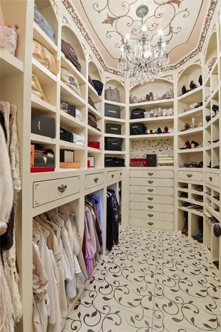 a view of walk in closet with clothes and shoes