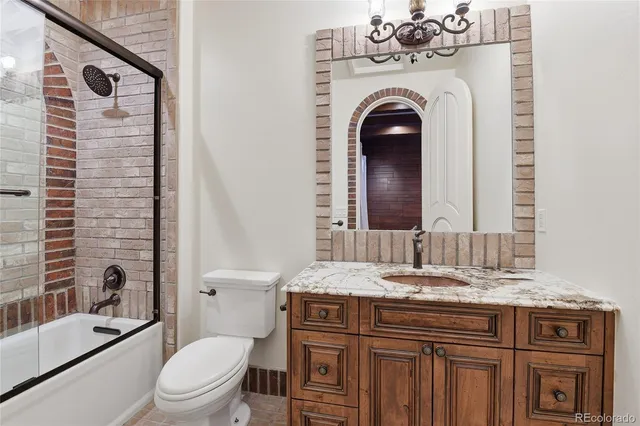 a bathroom with a granite countertop toilet a sink and a bathtub