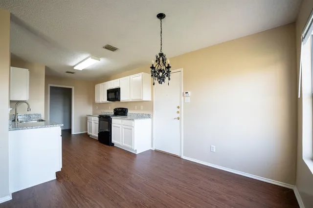 a view of a kitchen with a sink a refrigerator and a stove top oven