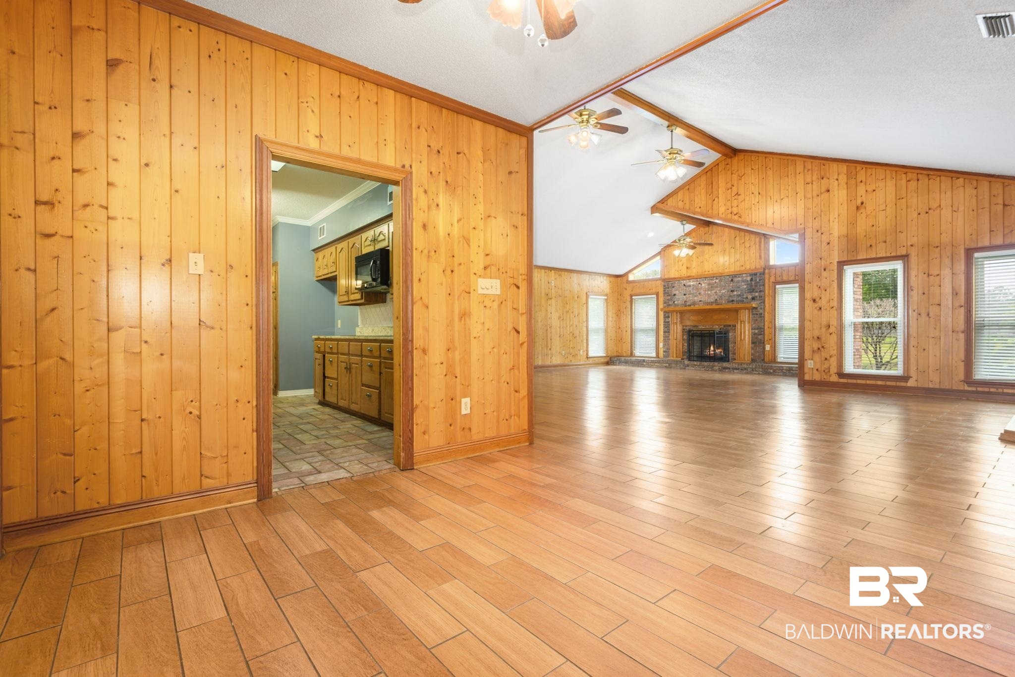 7540 2 Mile Road Irvington, AL 36544 - Photo 17 of 82 Spacious interior with extensive wood-paneling, high vaulted ceilings, and light wood-finish flooring
