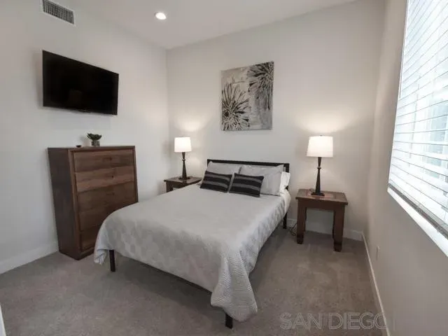 a bedroom with a bed and a flat screen tv