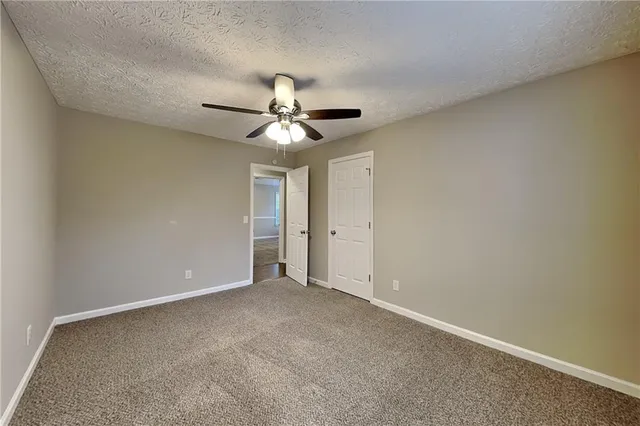 an empty room with a ceiling fan and a window