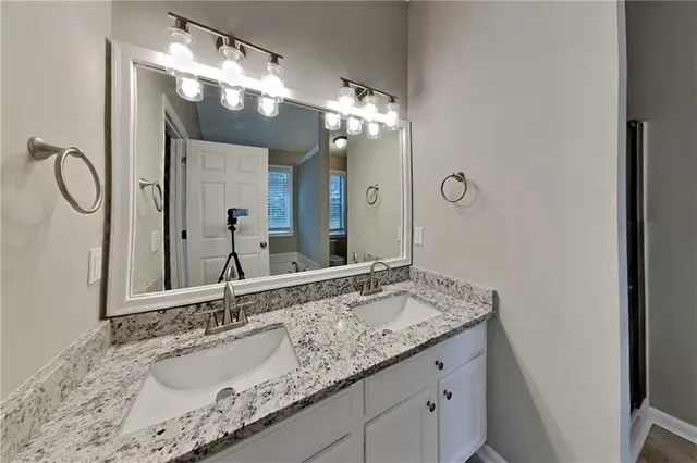 a bathroom with a granite countertop sink and a mirror