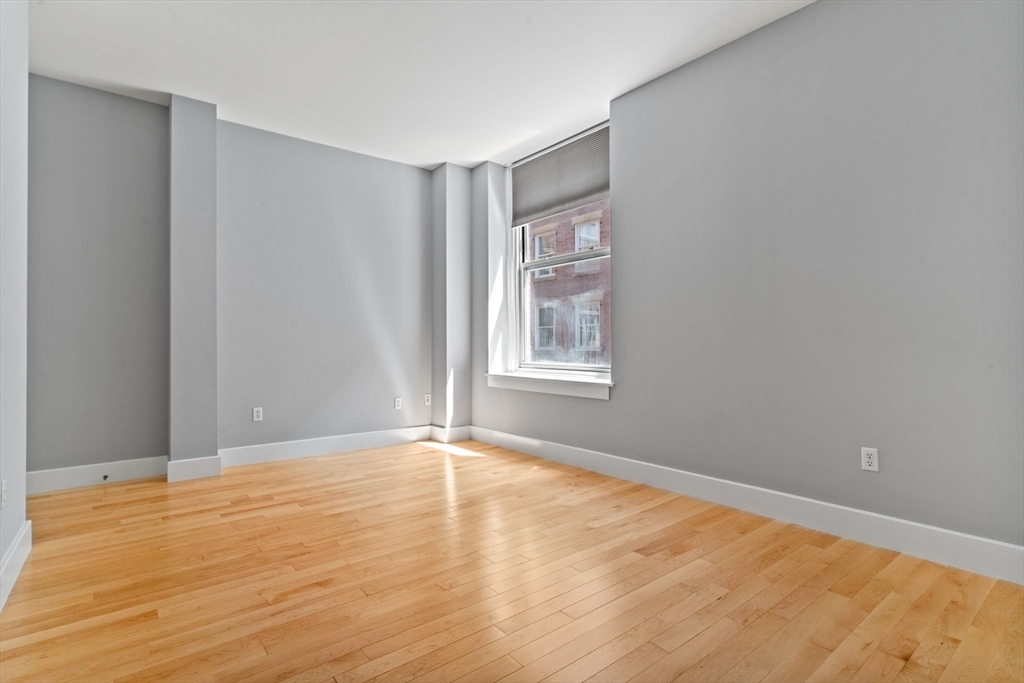 70 Lincoln Street, Unit L515 Boston, MA 02111 - Photo 11 of 16 a view of an empty room with wooden floor and a window