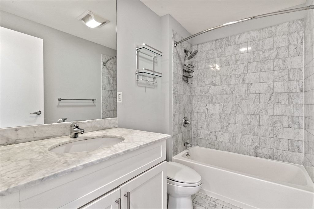 70 Lincoln Street, Unit L515 Boston, MA 02111 - Photo 9 of 16 a bathroom with a granite countertop sink a toilet and shower