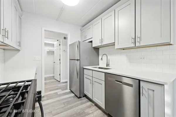 a kitchen with white cabinets and refrigerator