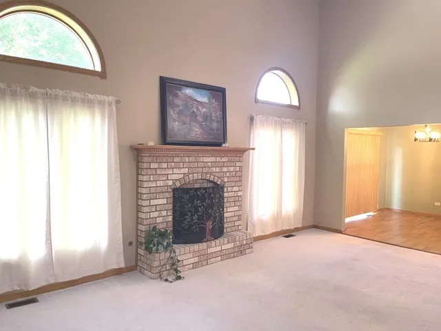an empty room with windows cabinet and fireplace