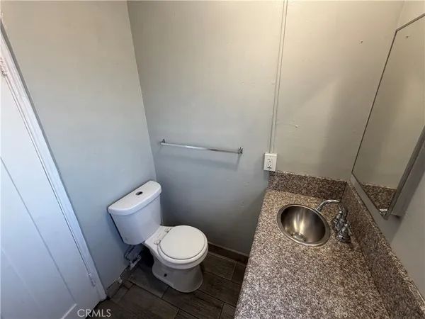 a bathroom with a granite countertop toilet and a sink