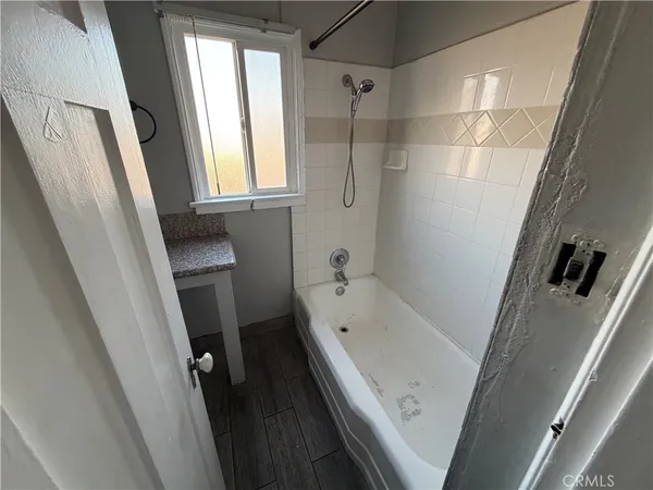 a bathroom with a tub a sink and a large window