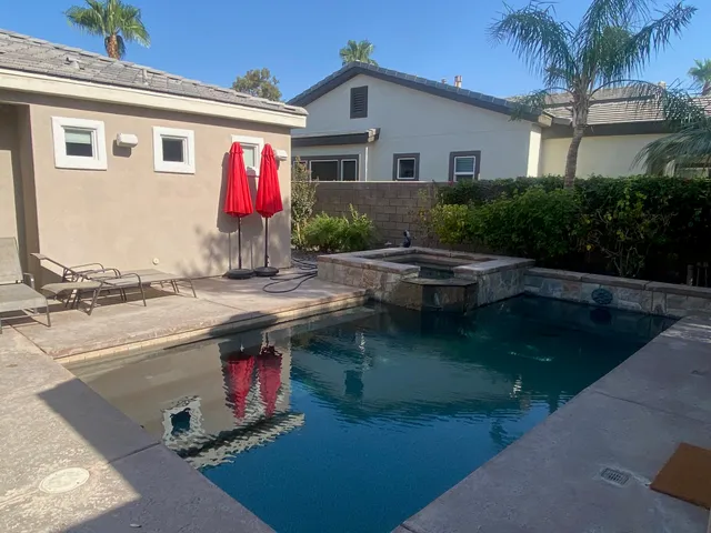 a kitchen with stainless steel appliances granite countertop a table chairs sink and cabinets