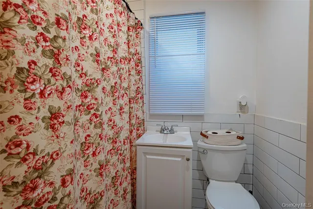 a bathroom with a toilet and a shower curtain