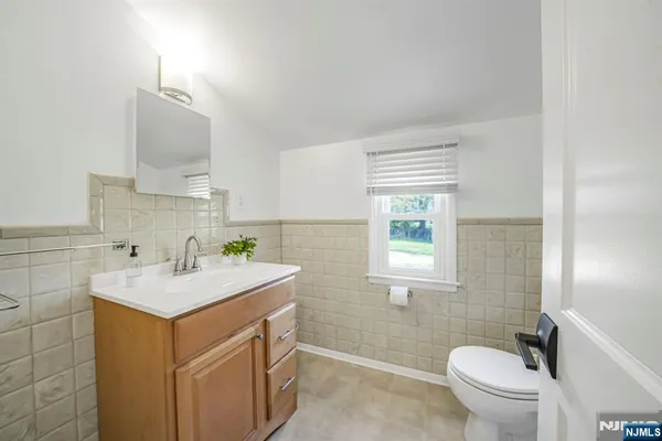 a bathroom with a sink toilet vanity and window