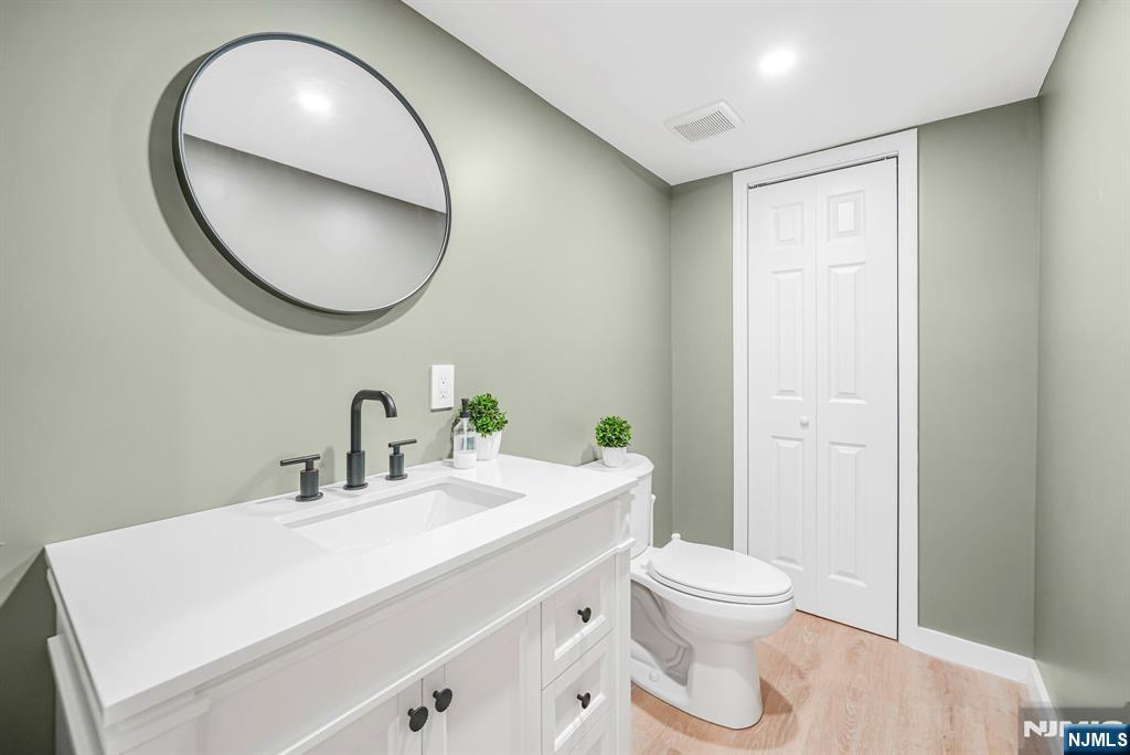 21 Joseph Place Wayne, NJ 07470 - Photo 24 of 32 a bathroom with a sink a mirror and a toilet