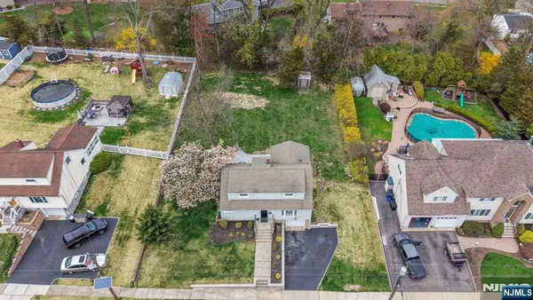 an aerial view of residential houses with outdoor space and parking