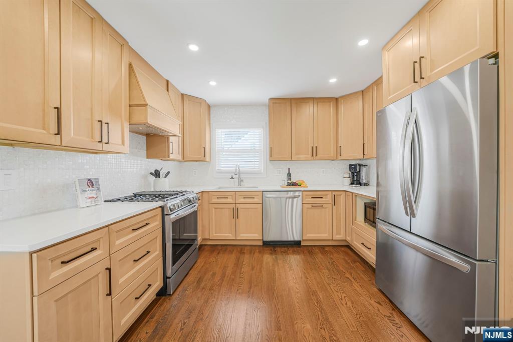 21 Joseph Place Wayne, NJ 07470 - Photo 7 of 32 a kitchen with white cabinets stainless steel appliances and wooden floor