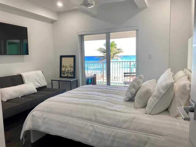 a bedroom with a bed painting on wall and a large window