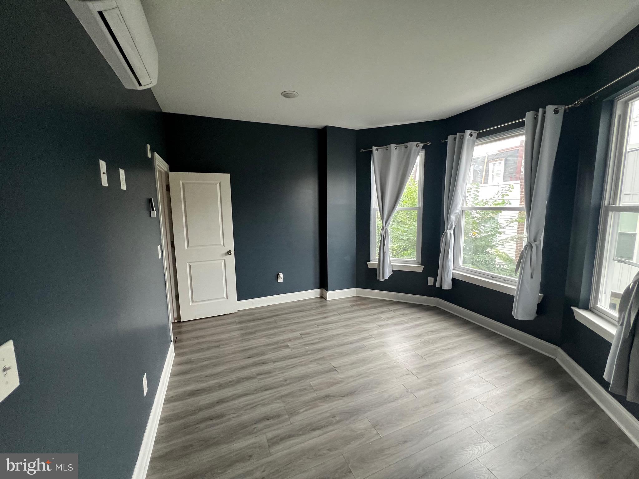1829 North 33rd Street, Unit 2R Philadelphia, PA 19121 - Photo 2 of 7 a view of an empty room with wooden floor and a window