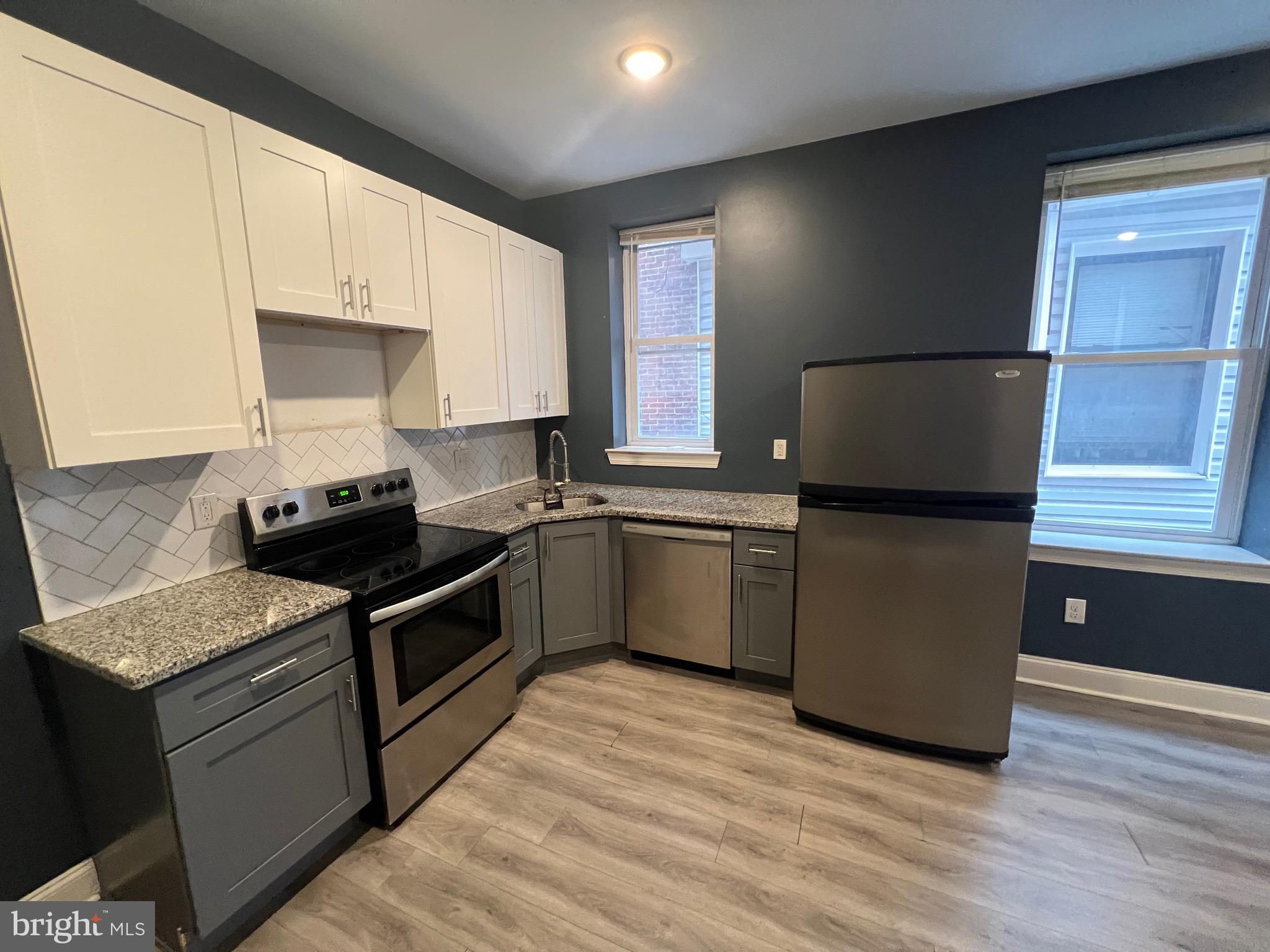 1829 North 33rd Street, Unit 2R Philadelphia, PA 19121 - Photo 6 of 7 a kitchen with granite countertop stainless steel appliances a sink cabinets and a window