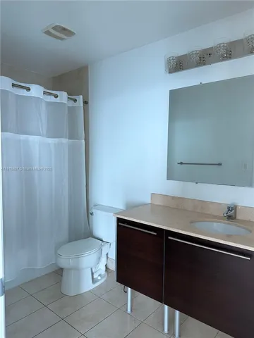 a bathroom with a sink a toilet a mirror and shower