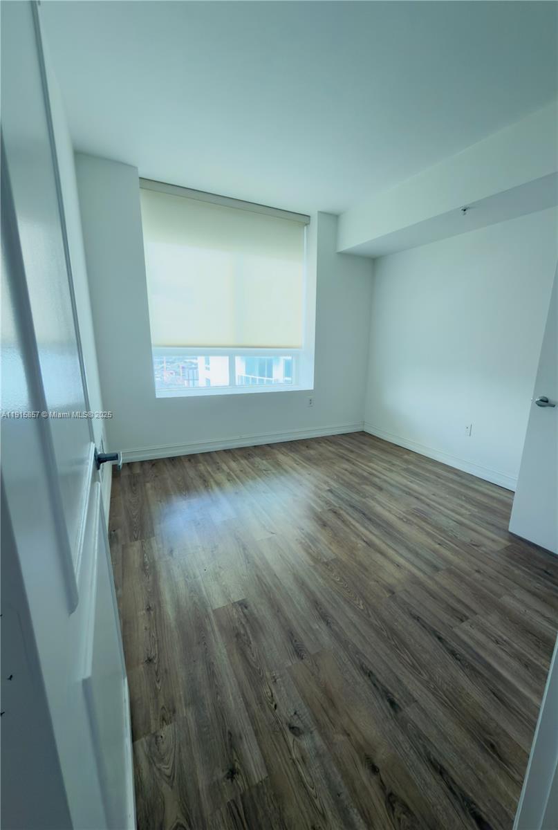 1900 North Bayshore Drive, Unit 3811 Miami, FL 33132 - Photo 7 of 27 an empty room with wooden floor and windows