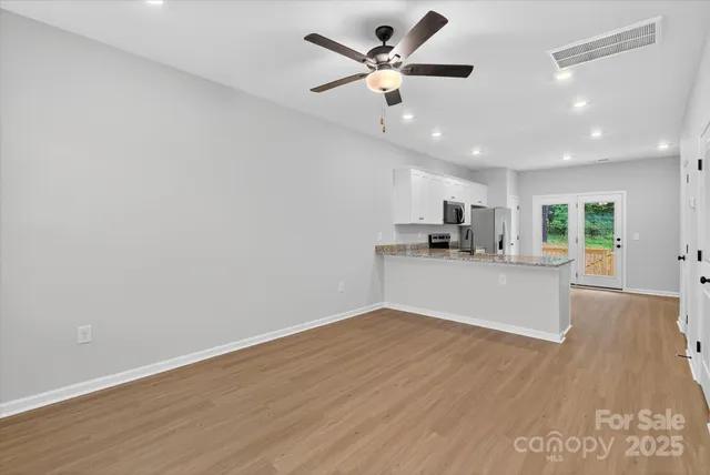 a view of a kitchen with a dishwasher and wooden floor