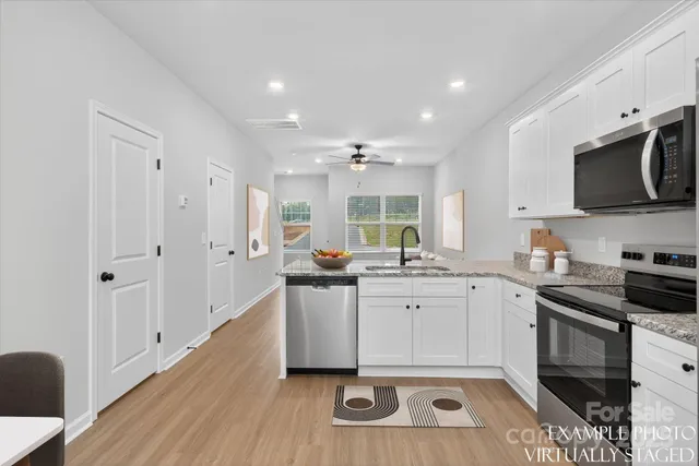 a kitchen with stainless steel appliances granite countertop a stove a sink and a refrigerator