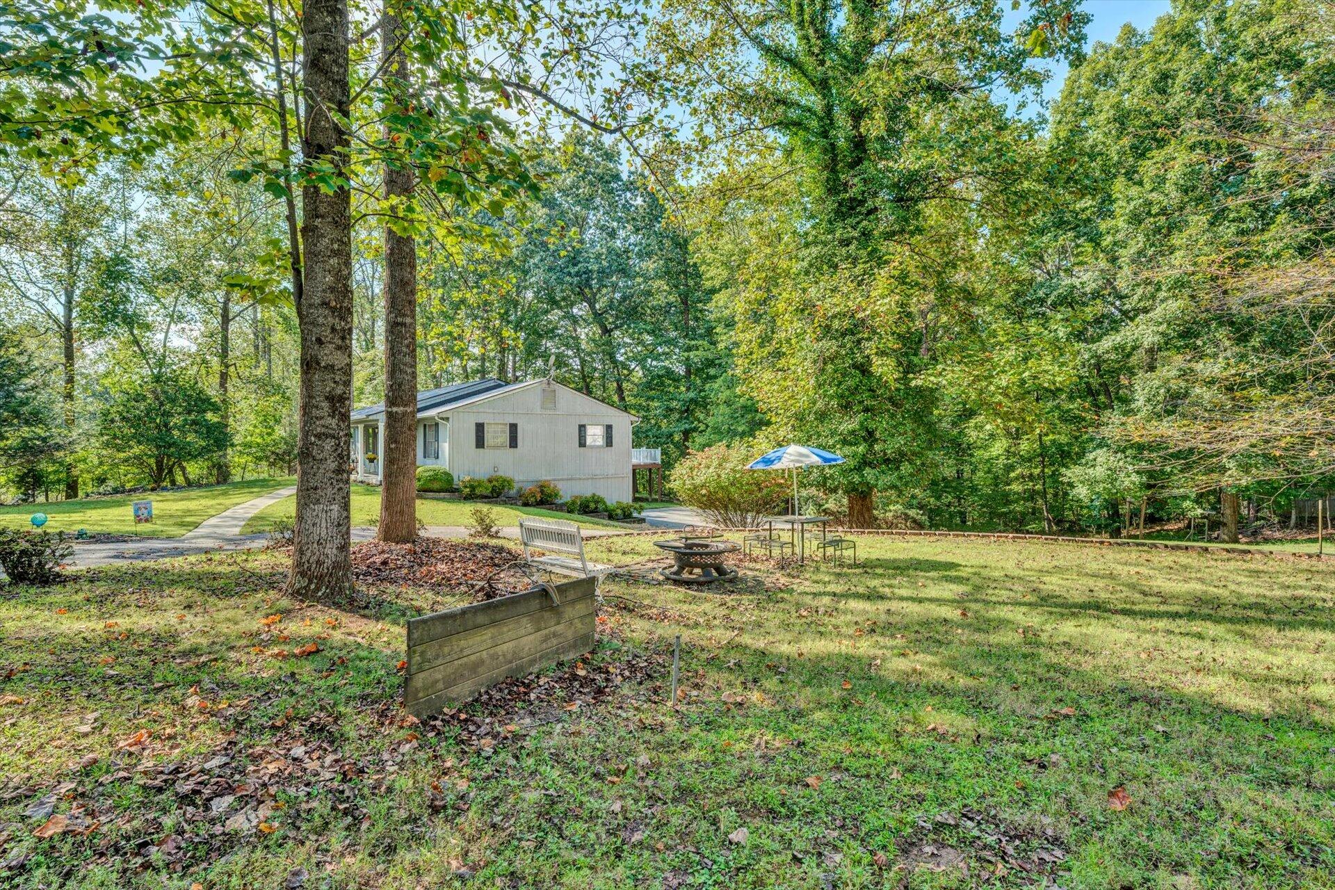 1319 Chandler Road Goodview, VA 24095 - Photo 47 of 53 a backyard of a house with trees and outdoor seating