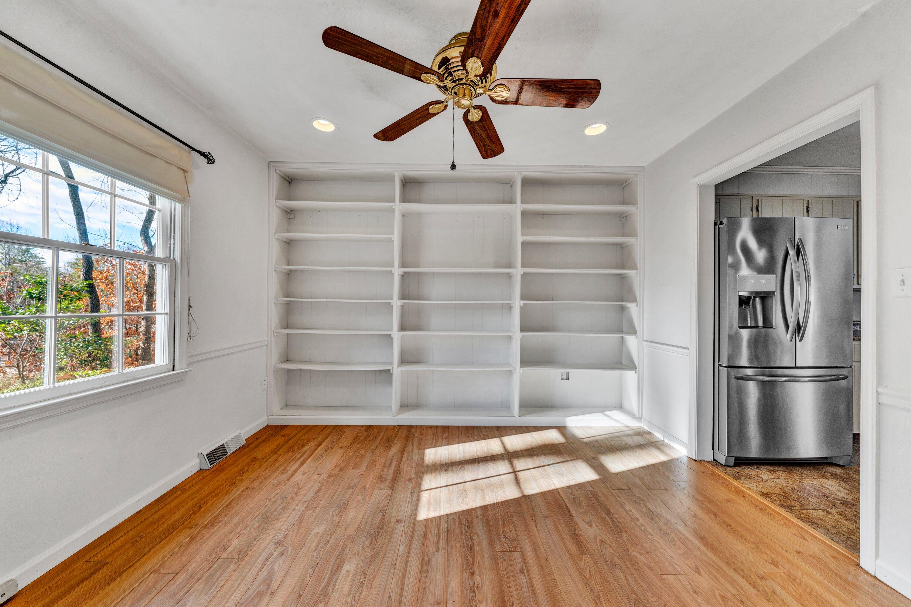 1319 Chandler Road Goodview, VA 24095 - Photo 9 of 53 a view of a room with wooden floor a ceiling fan and windows