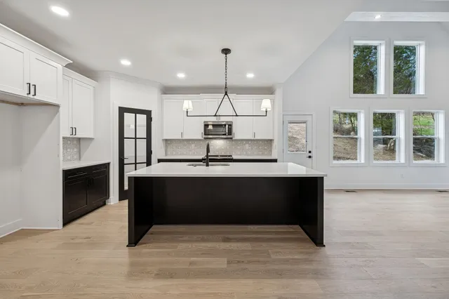 a large kitchen with kitchen island a sink stainless steel appliances and cabinets