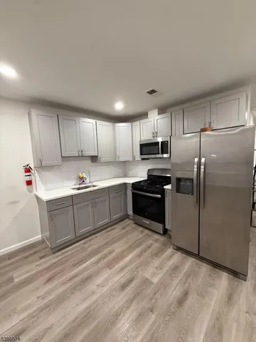 a kitchen with a refrigerator sink and cabinets