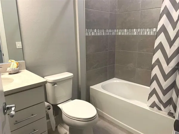 a white toilet sitting next to a bath tub
