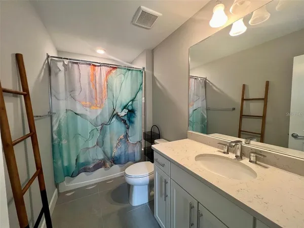 a bathroom with a granite countertop sink toilet and shower