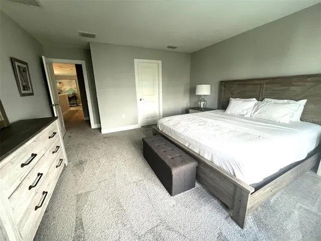 a bedroom with a bed and a flat tv screen on dresser