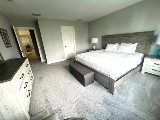 a spacious bedroom with a bed and a large mirror