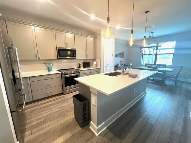 a kitchen with a sink stove and wooden floor
