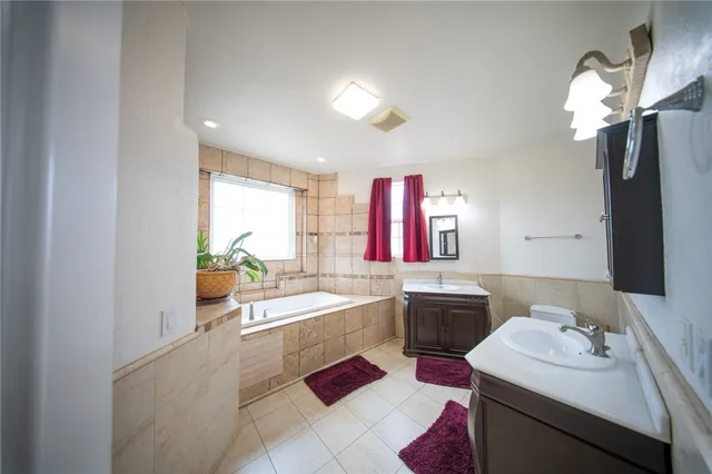 a bathroom with a bathtub sink and mirror