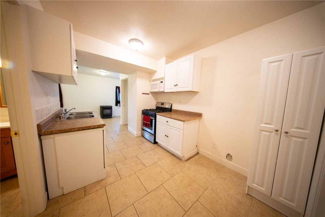 19701 Dovetail Court Tehachapi, CA 93561 - Photo 23 of 44 a kitchen with a sink a stove and cabinets