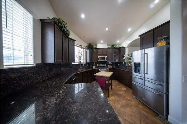 a kitchen with refrigerator a sink and chairs