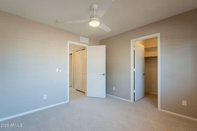 a view of an empty room and a ceiling fan window
