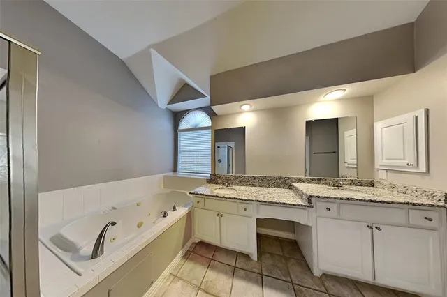 a bathroom with a granite countertop bathtub sink and mirror