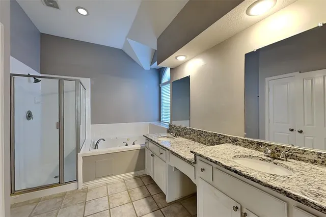 a bathroom with a granite countertop sink mirror and bathtub
