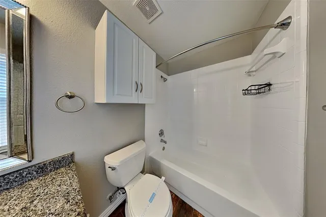 a white toilet sitting next to a bath tub