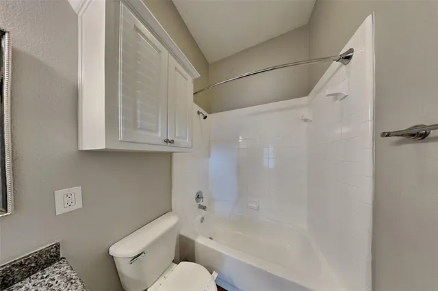 a bathroom with a shower a toilet and a sink