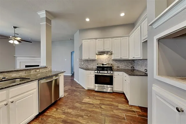 a kitchen with stainless steel appliances granite countertop a stove a sink and a refrigerator