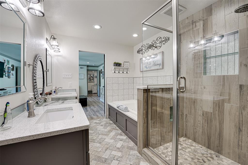 521 Bakers Branch Road Waxahachie, TX 75167 - Photo 26 of 37 Spacious primary bathroom featuring a glass-enclosed shower with pebble tile flooring and wood-look tile surround