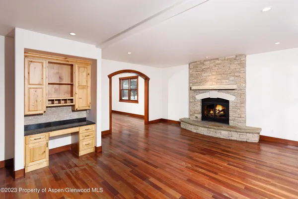 a living room with wooden floors and a fireplace