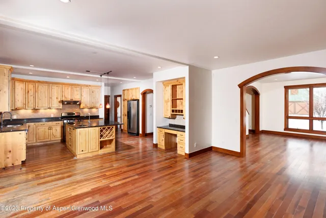 a view of a living room kitchen and kitchen with stove and wooden floor
